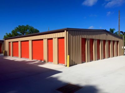 A storage building with orange doors and tan walls.