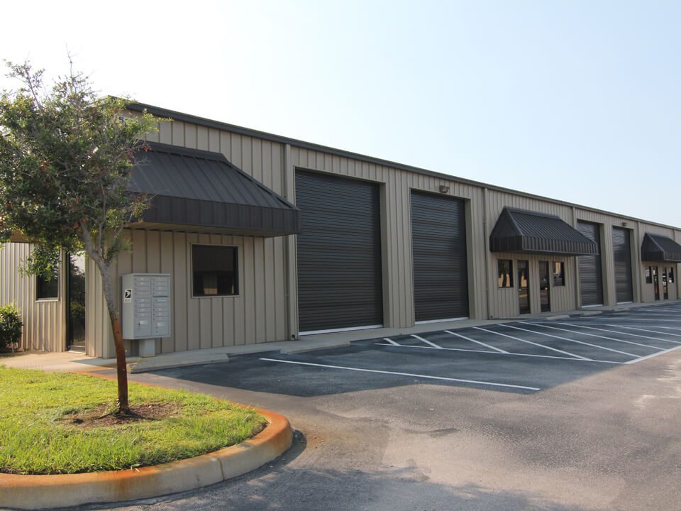 A building with three doors and a parking lot.