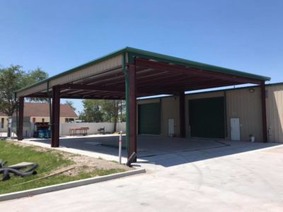 A large open carport with two doors and a metal roof.