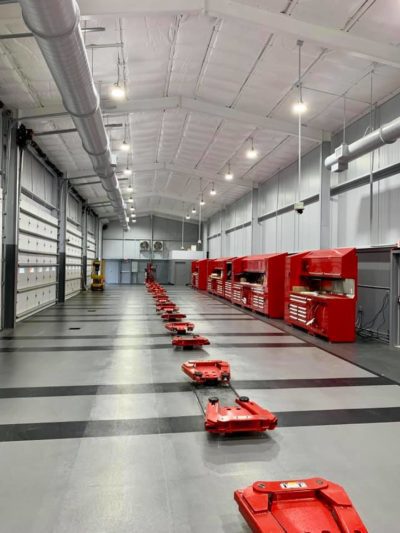 A warehouse with many red carts lined up.