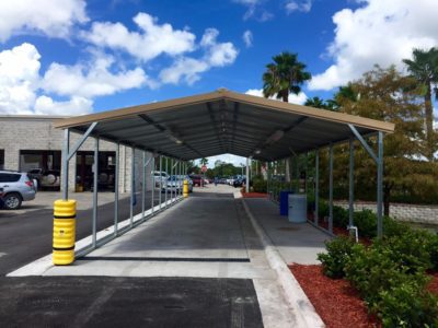 A parking lot with a metal roof and a blue sky.