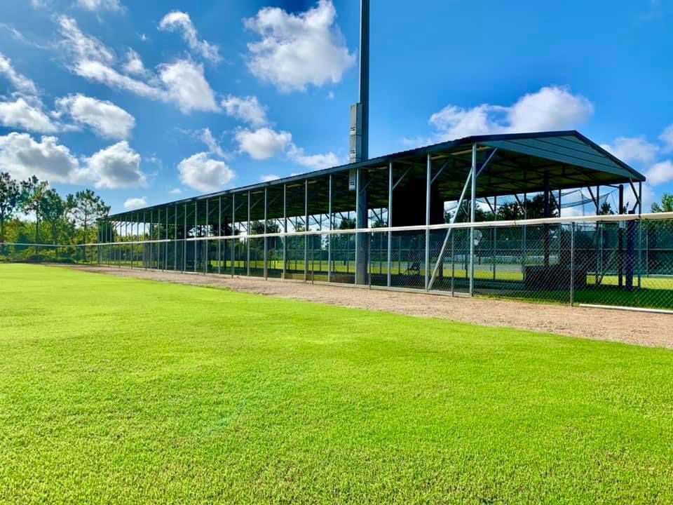 A baseball field with a blue sky and some clouds