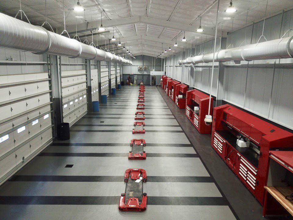 A long line of red cars parked in a garage.